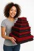 A woman is holding a stack of towels. Produktbild-Vorschau