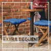 Two wooden chairs with blue cushions are placed around a small round table, with a brick wall in the background. Produktbild-Vorschau