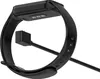 A black smart band charger connected to the underside of a smart band. Produktbild-Vorschau