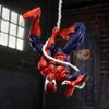A Spider-Man action figure is hanging upside down from a web in an urban alleyway. Podgląd zdjęcia produktu