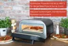 Der Unold Pizzaofen Don Luigi steht auf einer Holzplatte und backt eine Pizza. Zwei fertige Pizzen l Produktbild-Vorschau