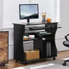 A black computer desk with a monitor, keyboard, mouse, and computer tower, placed near a window with blinds. Podgląd zdjęcia produktu