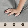 A hand is pressing into a grey fabric surface, likely demonstrating its softness or cushioning. There are three circular icons at the bottom of the image, suggesting product features. Anteprima dell’immagine prodotto
