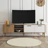 A modern TV stand with a TV on top, in a well-lit room. Produktbild-Vorschau