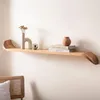 A wooden shelf mounted on a wall, decorated with a vase, a decorative sphere, and books. Voir les images du produit