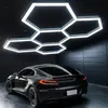 A black car is parked in a modern garage with hexagonal LED lights on the ceiling. Náhled obrázku produktu