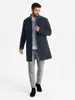 A man wearing a coat, sweater, and pants, standing against a white background. Anteprima dell’immagine prodotto