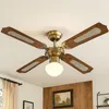 A close-up shot of a ceiling fan with wooden blades and brass accents, mounted on a white ceiling. Náhľad obrázku produktu