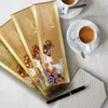 Several Lindt Swiss Premium Chocolate bars are arranged on a white surface next to two cups of espresso and a pen on a patterned napkin. Podgląd zdjęcia produktu