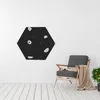 A hexagonal climbing wall with holds is mounted on a white wall next to a chair with a blanket. Podgląd zdjęcia produktu