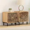 Two wooden nightstands with intricate carved designs are placed side-by-side against a white wall. A small potted plant sits on the left nightstand, and a table lamp with a circular base is on the right one. Podgląd zdjęcia produktu