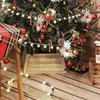 A Christmas tree with decorations and presents, including a wooden tree collar. Produktbild-Vorschau