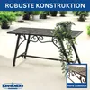 A black metal garden bench with ornate scrollwork and a potted plant on top, set on a light gray paved surface with other plants in the background. Náhľad obrázku produktu