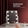 A makeup mirror with lights on a table, with a hand touching the screen. Podgląd zdjęcia produktu