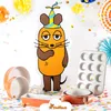 A cartoon mouse character stands next to baking pans and a muffin tin, surrounded by confetti and party decorations. Produktbild-Vorschau