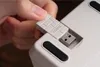 A hand is inserting a USB dongle into a device. Produktbild-Vorschau