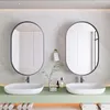 A modern bathroom vanity with two oval mirrors, two sinks, and a green countertop. Podgląd zdjęcia produktu