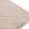 A close-up view of a beige quilted fabric, likely a cushion or mat, against a white background. Podgląd zdjęcia produktu