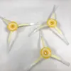 Four side brushes for a robot vacuum cleaner are laid out on a white surface. Voir les images du produit