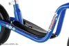 A close-up view of a blue children's balance bike, focusing on the frame, footrest, and wheel. Produktbild-Vorschau