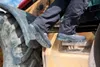 A person is stepping into a piece of heavy machinery, wearing work boots. Anteprima dell’immagine prodotto