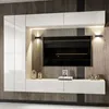 A modern white entertainment center with a large television mounted on a slatted wood panel wall. Produktbild-Vorschau