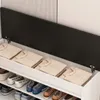 A shoe cabinet with its lid open, revealing folded sweaters inside and shoes on shelves below. Podgląd zdjęcia produktu