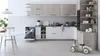 A modern kitchen with a dishwasher open and a toy car in the foreground. Voir les images du produit