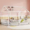A white house-shaped bed frame with a mattress and several stuffed animals inside, set against a pink and yellow wall. Produktbild-Vorschau