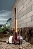 A sledgehammer rests on the ground next to a brick wall under a cloudy sky. Náhľad obrázku produktu