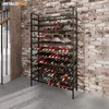 A metal wine rack filled with wine bottles, standing against a brick wall next to a staircase. Náhľad obrázku produktu