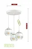 A white triple pendant light with glass globes against a white background. Podgląd zdjęcia produktu