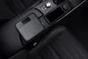 The product is placed in the center console of a car, next to a smartphone. Produktbild-Vorschau