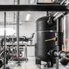 Industrial setting with large black pipes and a black tank. Produktbild-Vorschau