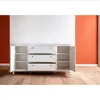 A white dresser with drawers and open cabinets is shown in a room with white and orange walls. Náhľad obrázku produktu