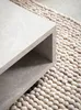 A close-up of a modern coffee table with a marble-like finish, placed on a textured rug. Anteprima dell’immagine prodotto