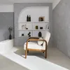 A minimalist living room scene with a chair and shelving unit. Produktbild-Vorschau