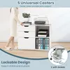 A woman is standing next to a white rolling storage unit with drawers and shelves, which holds a printer, files, and other office supplies. The image highlights the unit's casters and lockable design. Podgląd zdjęcia produktu