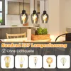 A kitchen or dining area with pendant lights hanging over a table, and a selection of light bulbs displayed below. Produktbild-Vorschau
