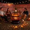 Three people sitting around a fire pit on a patio at night, with string lights overhead. Anteprima dell’immagine prodotto