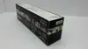 A black box with images and text on it, likely a product package, is shown at an angle on a white and gray surface. Podgląd zdjęcia produktu