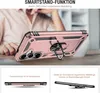 A person's hand is holding a rose gold phone case with a ring stand on a table. Produktbild-Vorschau