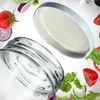 A glass jar and its lid are shown with various salad ingredients floating around them. Produktbild-Vorschau
