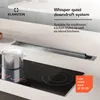 A modern kitchen countertop featuring a built-in downdraft ventilation system over an induction cooktop, with a pot of boiling water on the cooktop. Náhľad obrázku produktu