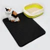 A cat toy and a litter box are placed on a black mat. Voir les images du produit
