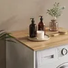 A washing machine cabinet with decorative items on top. Anteprima dell’immagine prodotto