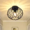 A black, cage-like ceiling light fixture with a visible light bulb, mounted on a white ceiling. Produktbild-Vorschau