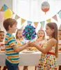 Children celebrating a birthday party, with a boy presenting a bouquet of artificial flowers to a girl. Náhľad obrázku produktu