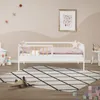 A child's bedroom with a white toddler bed, a rug, and toys. Produktbild-Vorschau