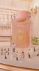 Miniature figures are cleaning a giant perfume bottle. Voir les images du produit